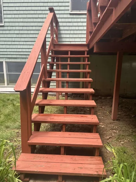 A set of wooden stairs leading up to a house.