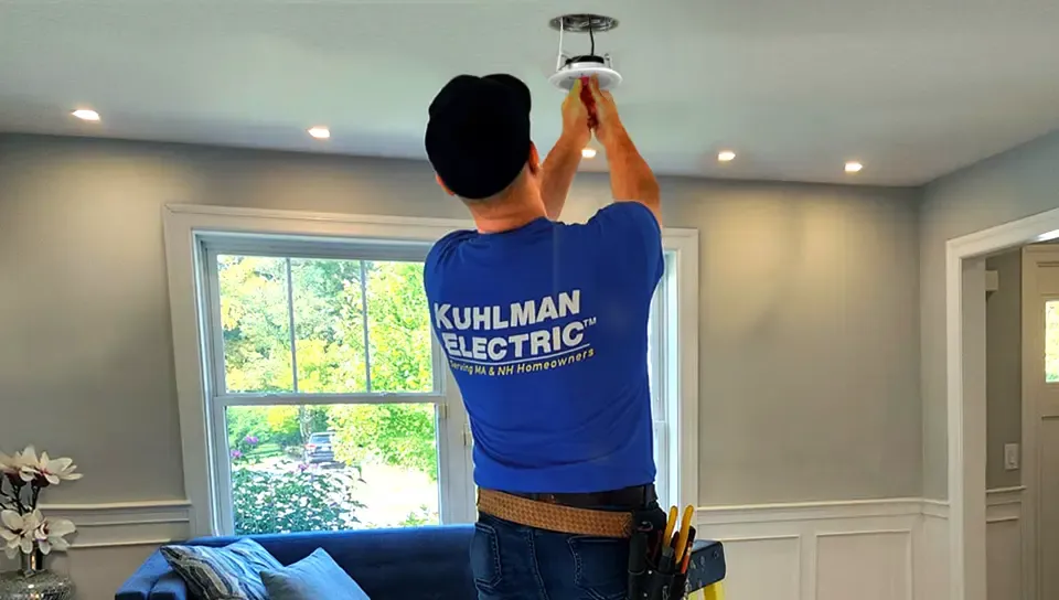 Kuhlman Electric electrician installing recessed lighting in a living room ceiling.
