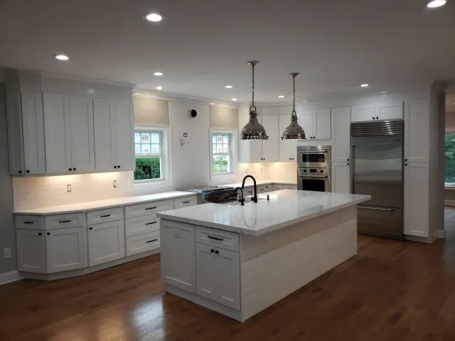 White shaker kitchen with quartz island and pendant lights