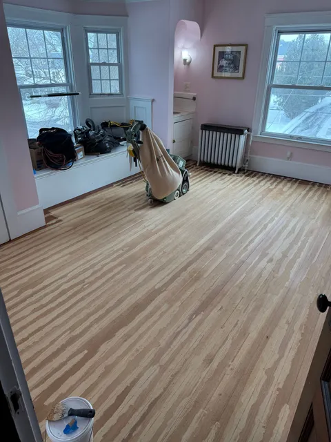Hardwood floor mid-refinish with the drum sander on site