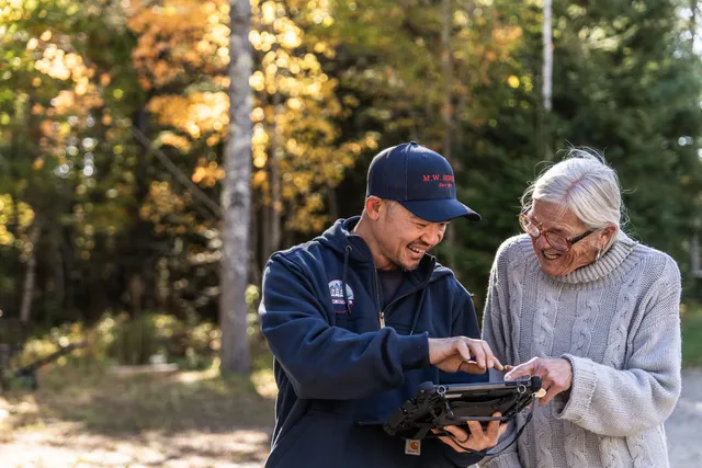 M.W. Sewall service technician discussing high-efficiency heating maintenance with a customer in West Bath, Maine.