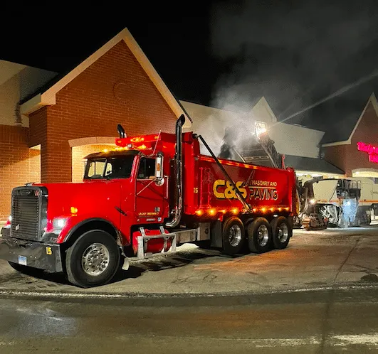 Heavy-duty milling equipment removing the top layer of old pavement to prepare for a new surface in Watertown.
