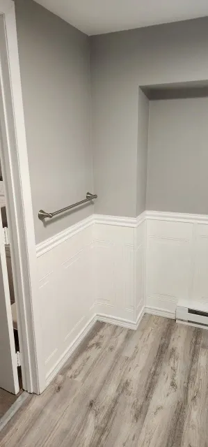 A bathroom with gray walls and a wooden floor.