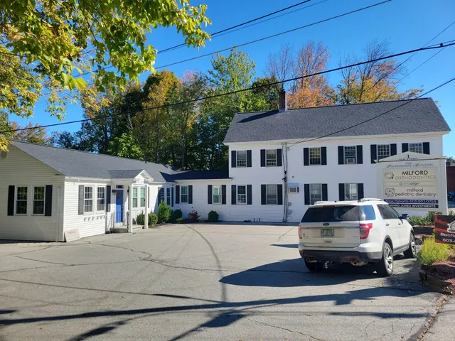 White-two-story-dental-office-building-with-a-white-SUV-in-the-driveway