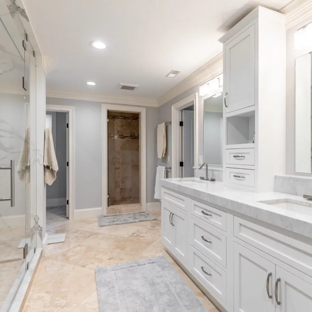 A roomy bathroom equipped with white cabinets and a luxurious walk-in shower.
