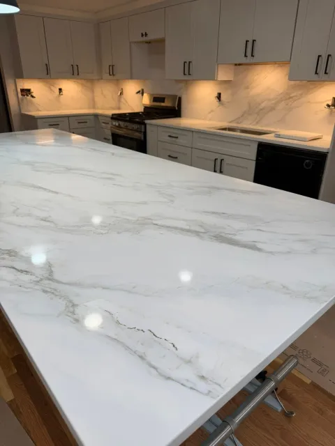 White marble kitchen island with gray veining in a modern white kitchen