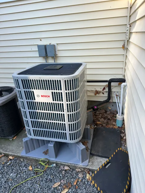Bosch outdoor condenser unit installed beside a home by Service Solutions in Central Massachusetts