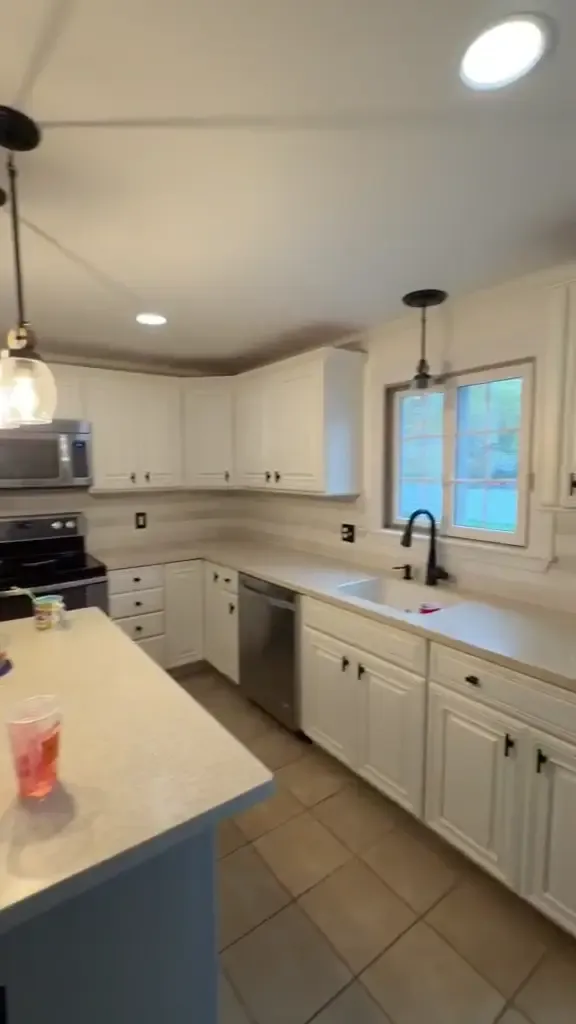 A finished kitchen with white cabinetry, a contrasting island and close finish detail.