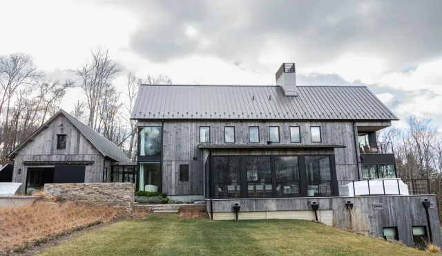 A large house with a lot of windows and a large lawn in front of it.