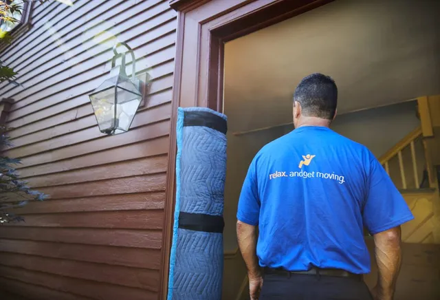 Mover carrying padding into a home