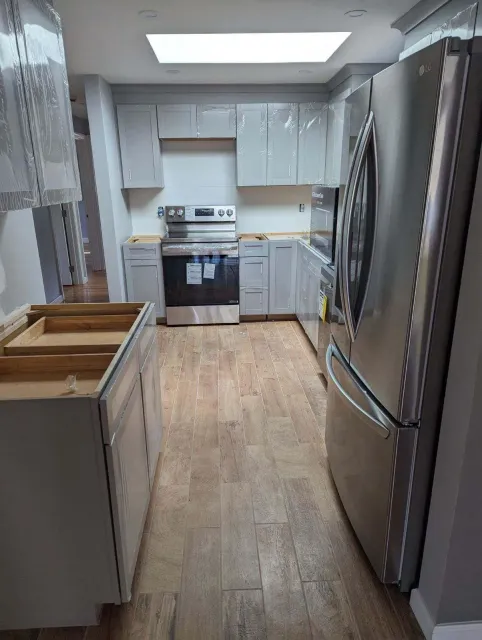 A kitchen with stainless steel appliances and white cabinets.