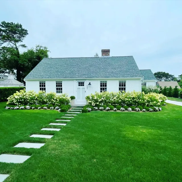 Bright white house with clean windows and beautiful landscaping | Exterior window cleaning Cape Cod