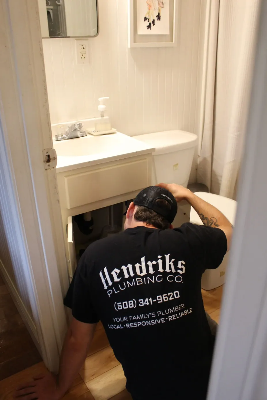 Plumber working under bathroom sink