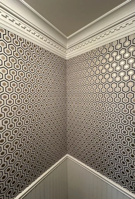 A corner of a room with a pattern on the wall.