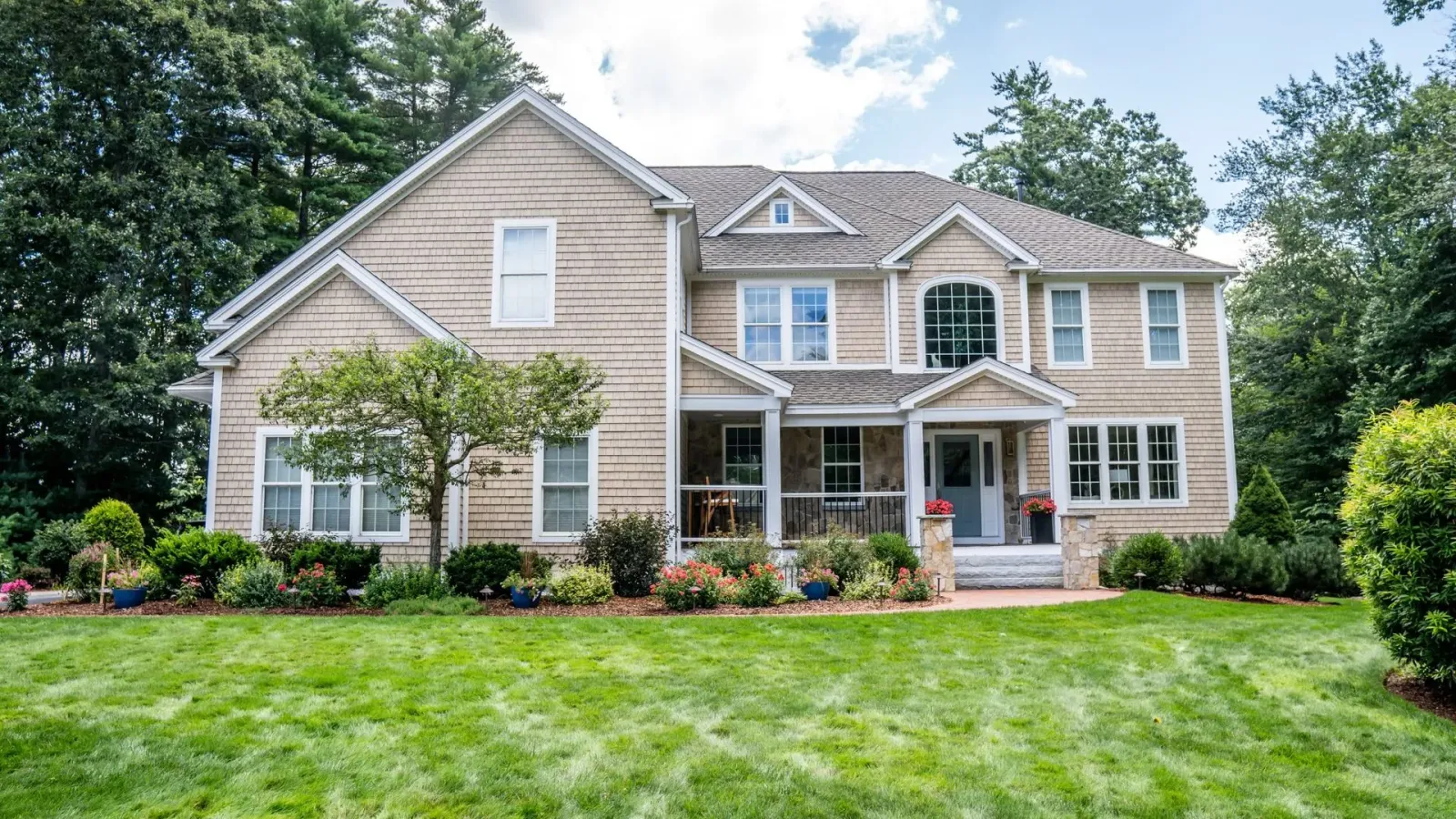 A large house with a lush green lawn in front of it.