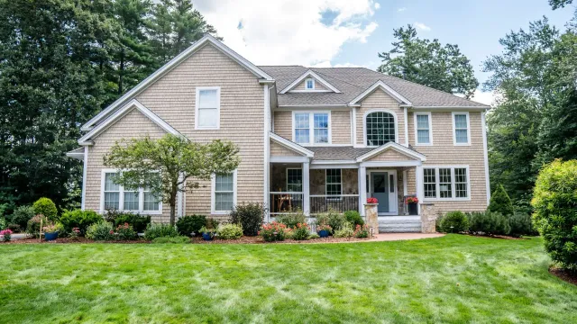 A large house with a lush green lawn in front of it.