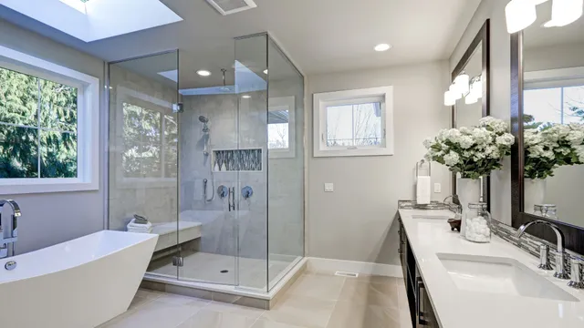 Luxury bathroom renovation in Hampton, NH with a custom tile shower, glass shower enclosure, floating vanity, and freestanding tub