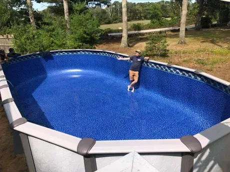 A man is standing in the middle of a large swimming pool.