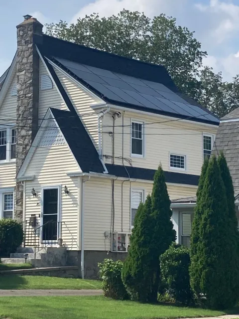 A white house with solar panels on the roof