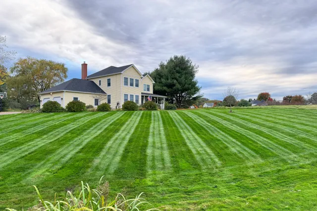 A house with a freshly mowed lawn after a lawn care service near me
