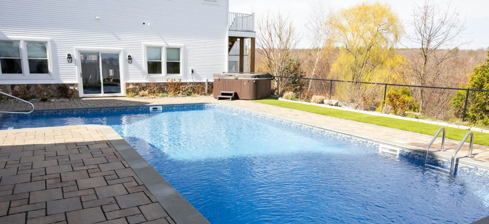 A pool with a hot tub in the back yard.