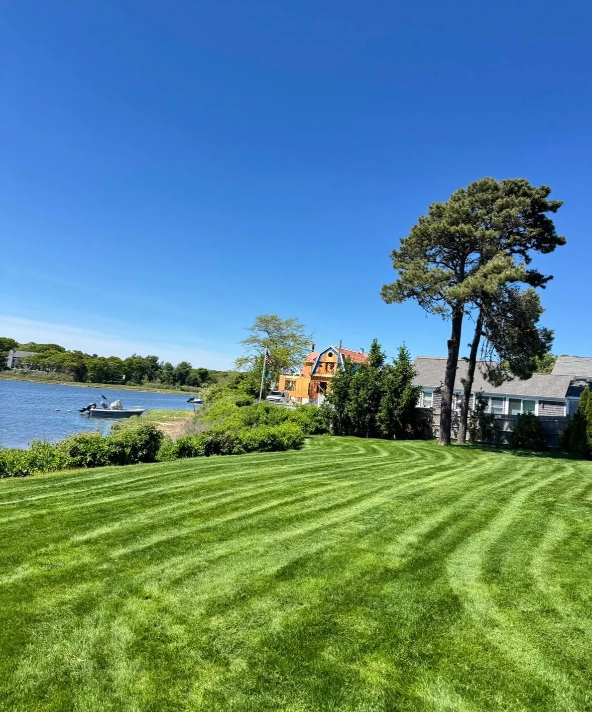 Striped waterfront lawn under a blue sky