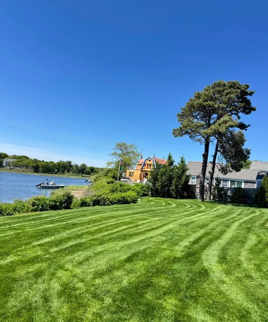 Striped waterfront lawn under a blue sky