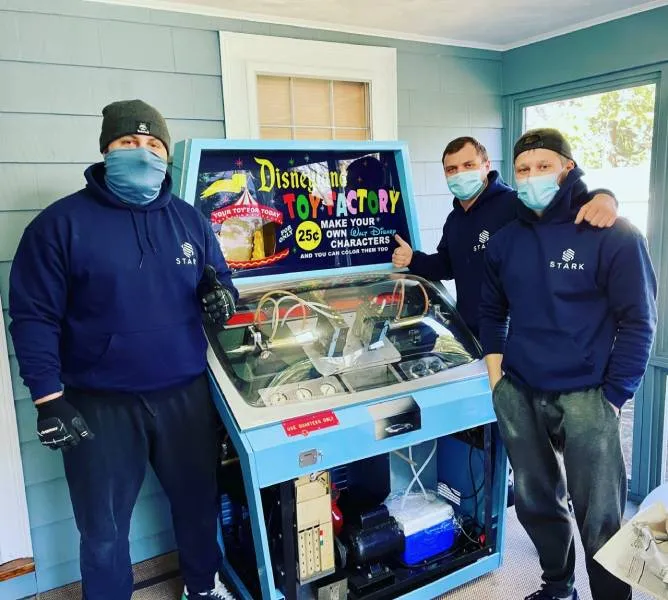 movers standing next to a game console preparing for amove