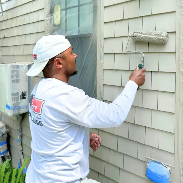 Exterior house painting project showcasing fresh coastal home siding and trim.
