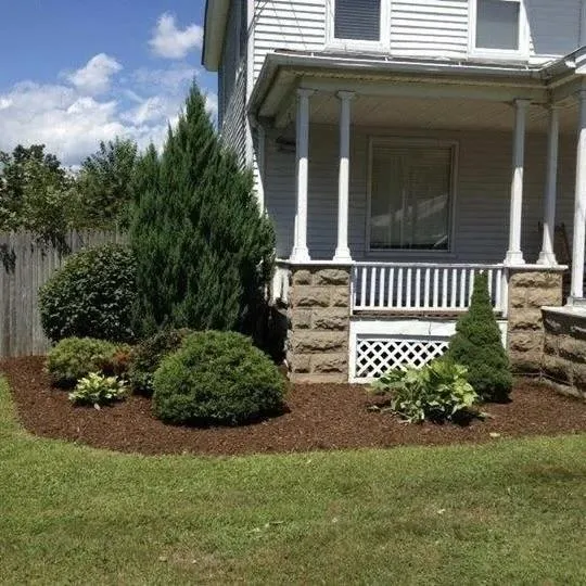 Fresh mulch and shrub landscaping around a residential front porch