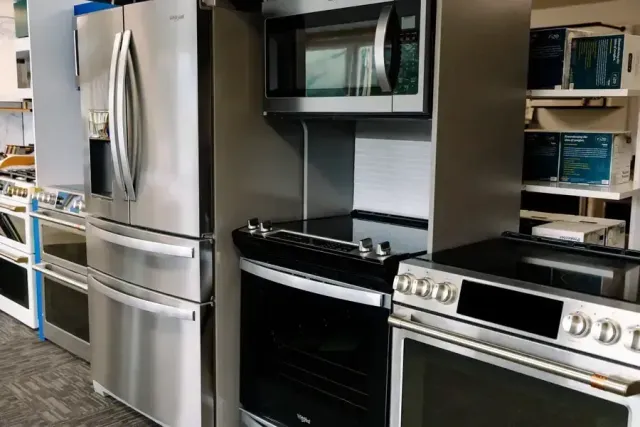 A kitchen with a refrigerator , microwave , oven and stove.
