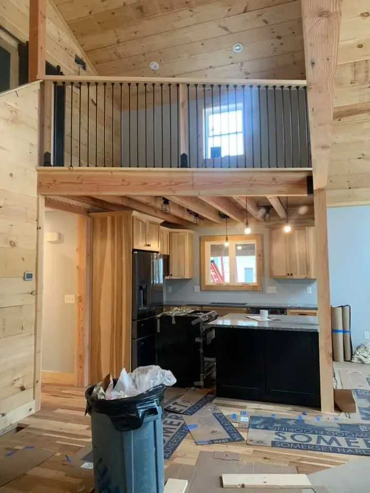 A kitchen with a trash can in the middle of it.