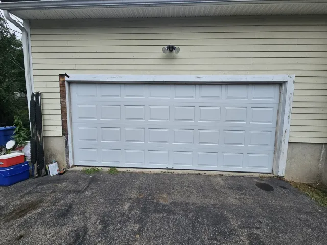 New white raised-panel garage door installed in the same opening, Methuen MA