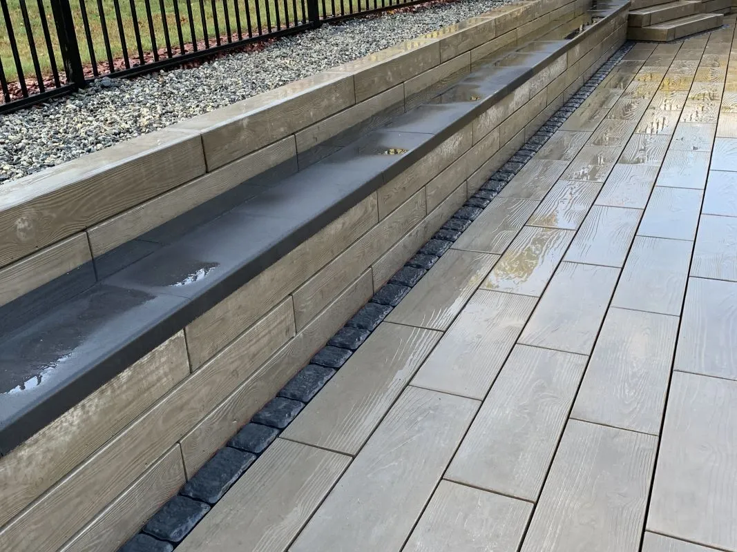 Custom sitting wall and patio installation in Westwood, MA by Goodwood General Construction, featuring sleek stone finishes for enhanced outdoor spaces.