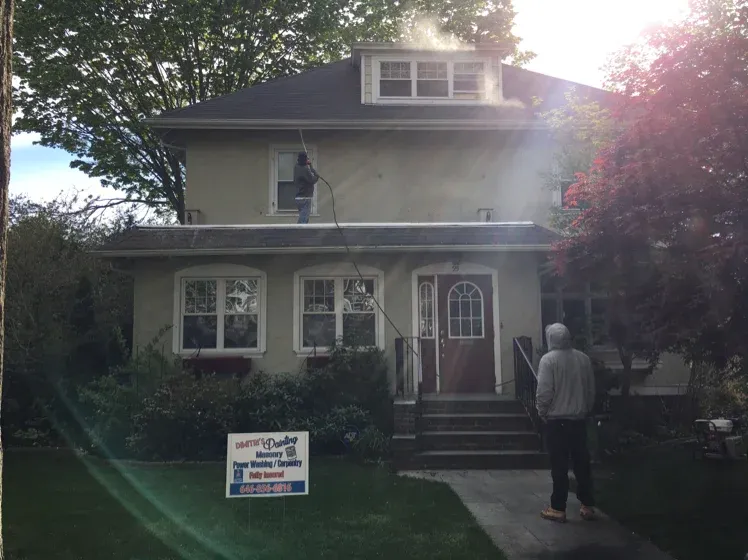 Exterior painting job in progress with company job sign