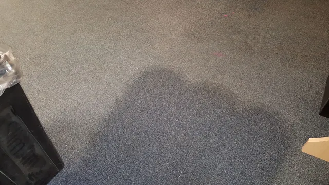 a gray carpeted floor with speakers on it in a room