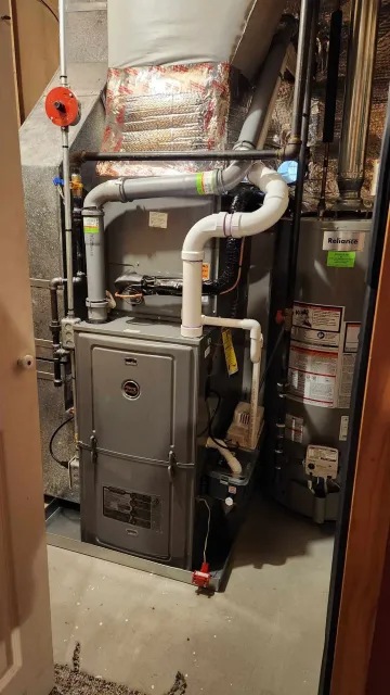 A utility room with HVAC and water heating equipment, including pipes, a furnace, a water heater, and insulation.