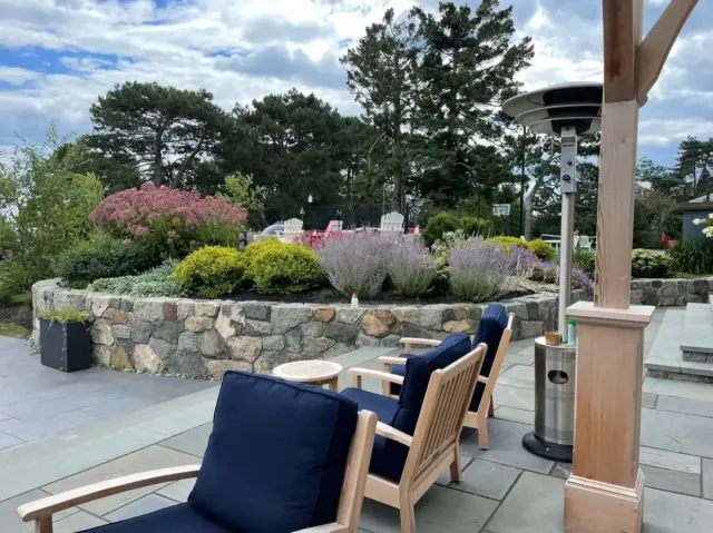 Bluestone patio with custom landscape  natural stone retaining wall and landscaped outdoor living area in Marblehead, MA