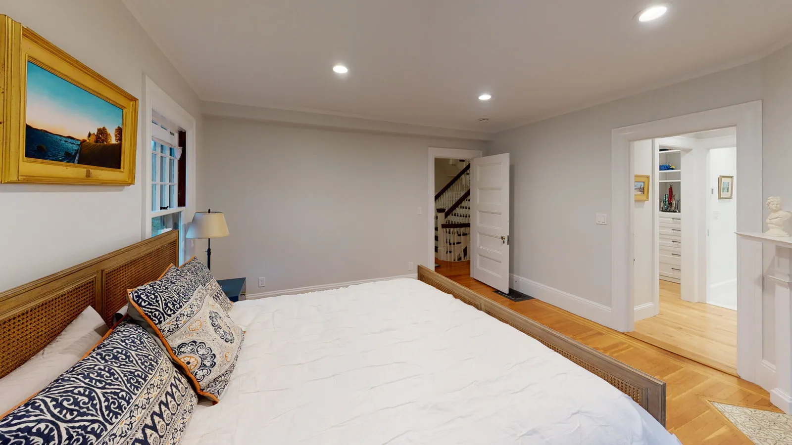 Primary bedroom opening to a walk-in closet and stair hall