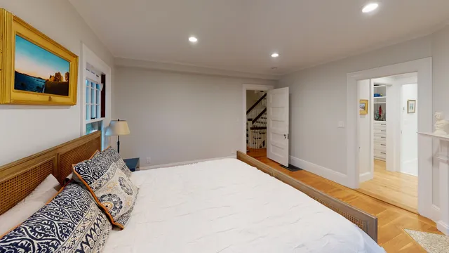 Primary bedroom opening to a walk-in closet and stair hall