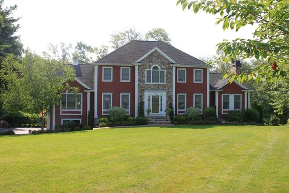 Red custom colonial with stone-clad entry gable