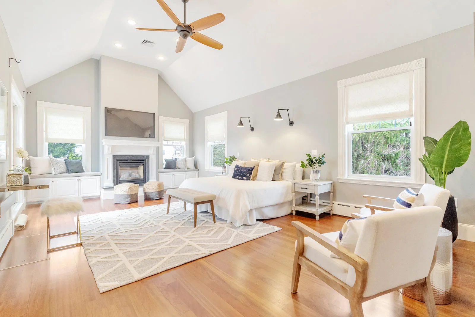 Primary bedroom with vaulted ceiling, fireplace and window seats