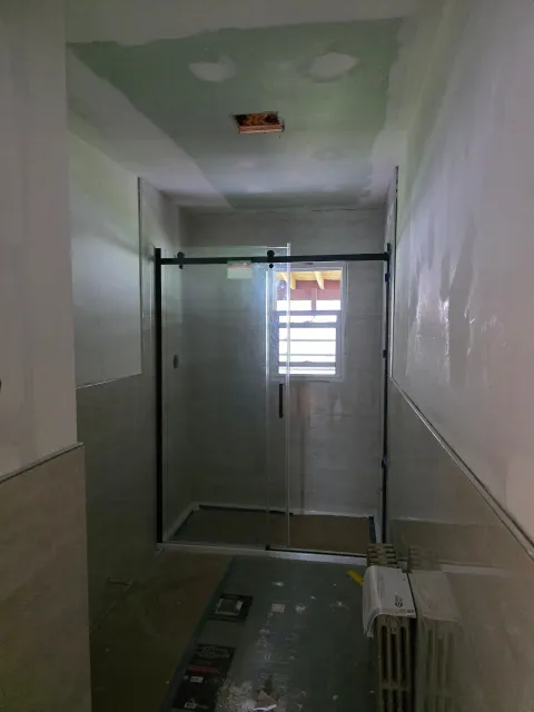 A bathroom with a sliding glass door and a window.