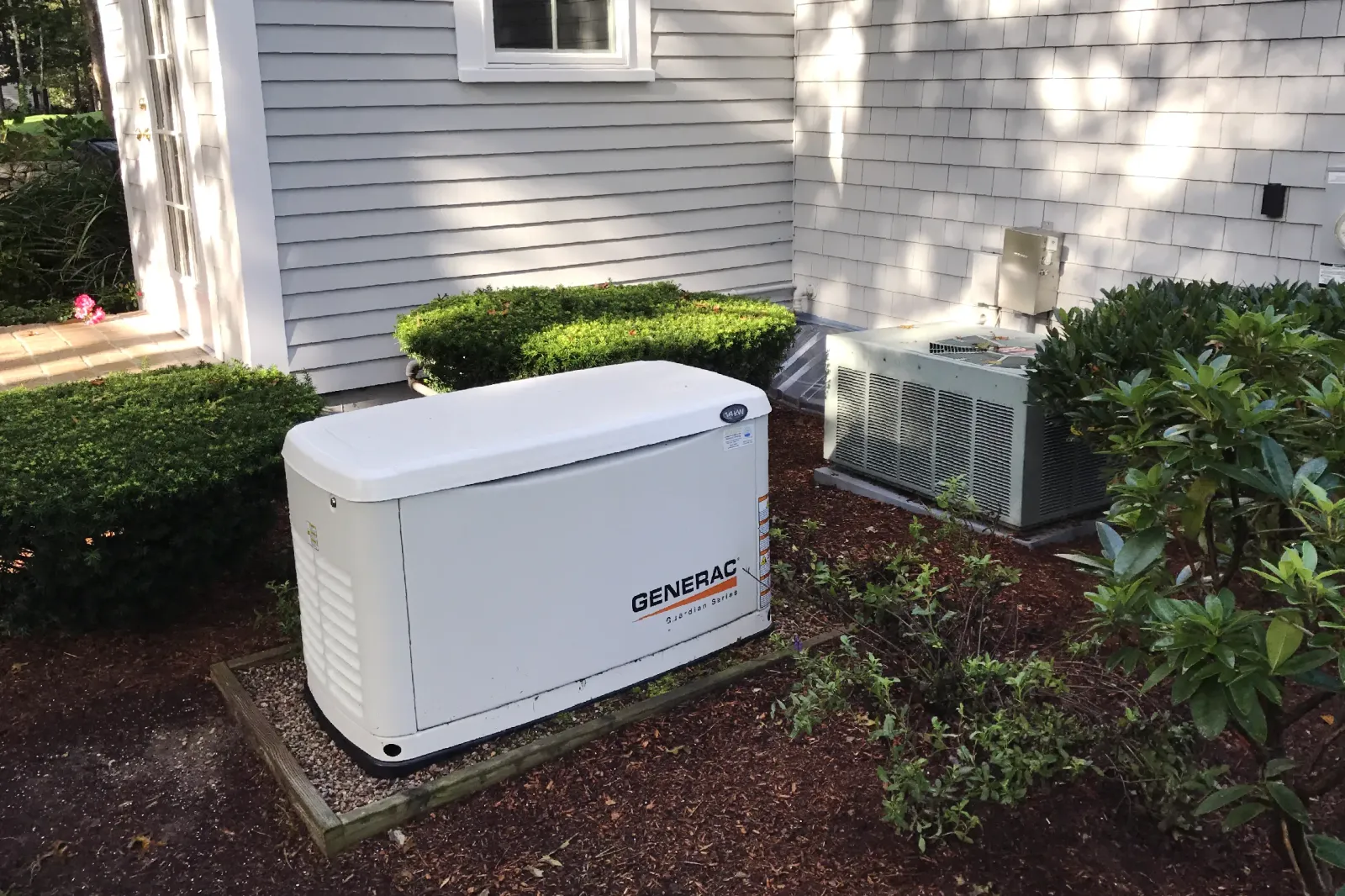 A Generac automatic standby generator installed by Robies next to a Cape Cod home, providing reliable backup power during nor'easters and storm outages year round