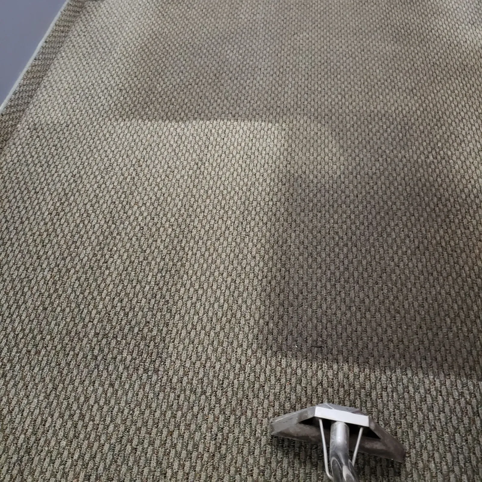 a close up of a carpet with a vacuum cleaner on it