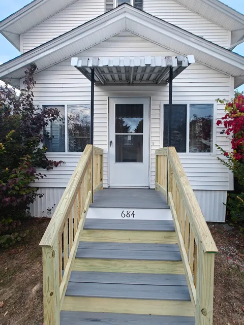 Front steps after rebuild with fresh railings and clean finish