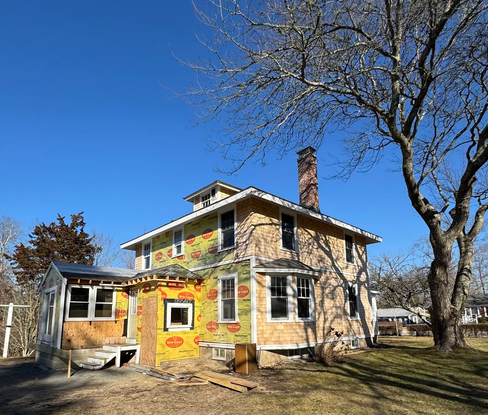 Whole-house renovation mid-build with new shingles and weather barrier