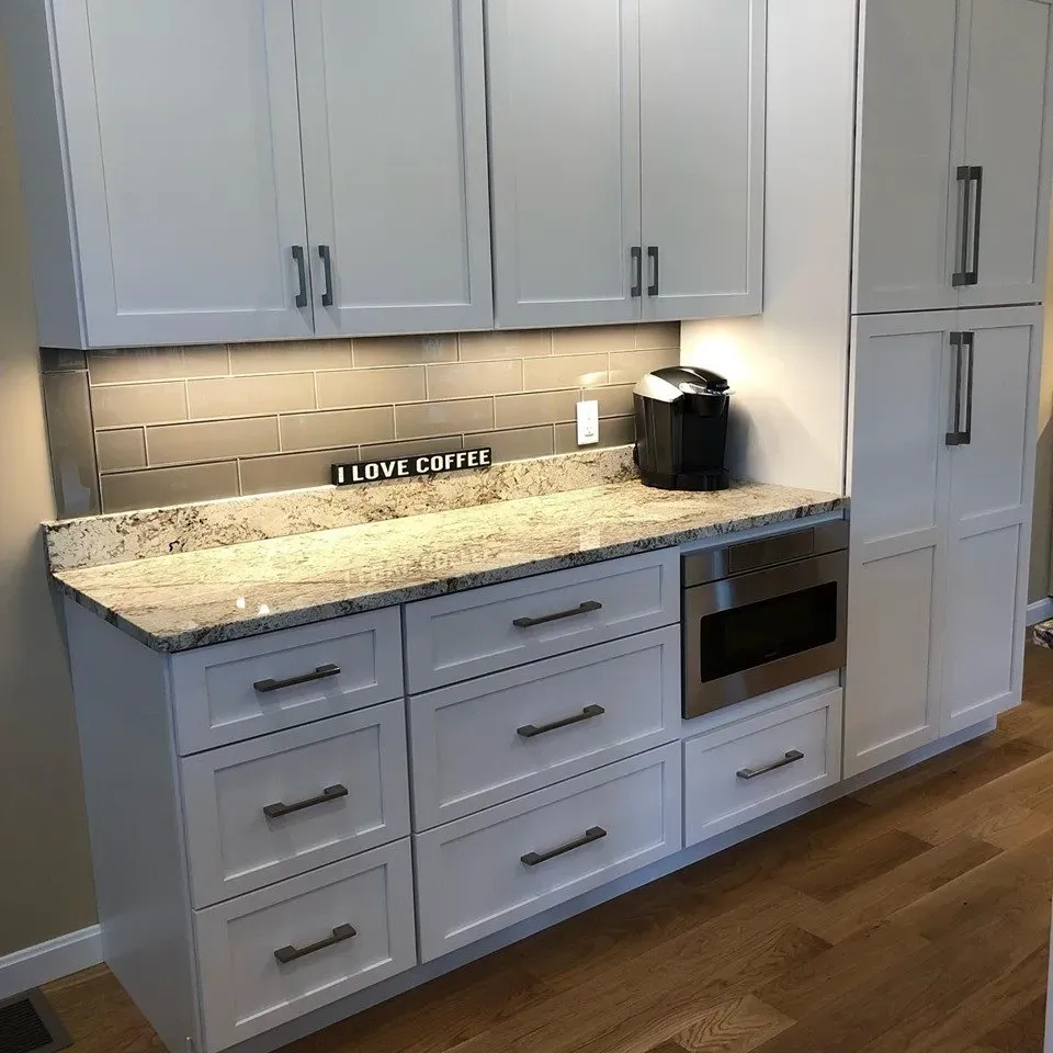 A kitchen with white cabinets and granite counter tops and a sign that says i love coffee.