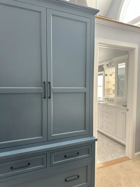 A bathroom with a blue cabinet and white cabinets