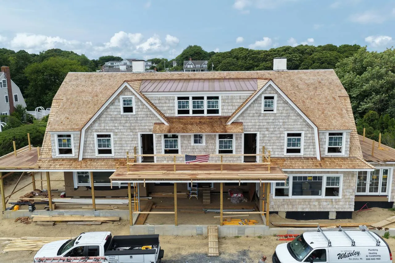 Sweeping gambrel roof covered in fresh red cedar shingles